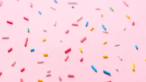 Colorful Sprinkleson Pink Background Wallpaper