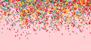 Colorful Sprinkleson Pink Background Wallpaper