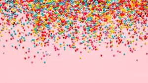 Colorful Sprinkleson Pink Background Wallpaper