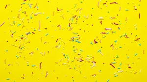 Colorful Sprinkleson Yellow Background Wallpaper
