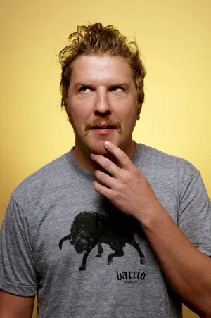 Comedian Nick Swardson, On Stage In Front Of A Microphone Wallpaper