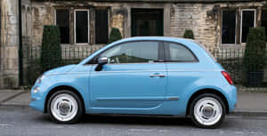 Compact Car Driving Along A Scenic Road Wallpaper