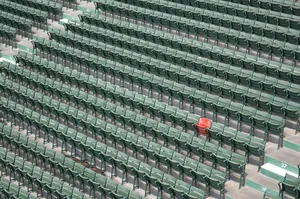 Conspicuous Red Chair In A Row Of Green Chairs Wallpaper