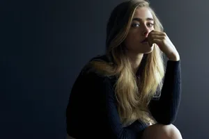 Contemplative Blonde Woman Dark Backdrop Wallpaper