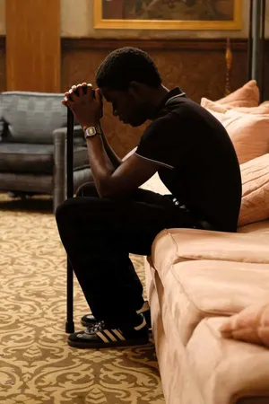 Contemplative Man Seatedon Couch Wallpaper