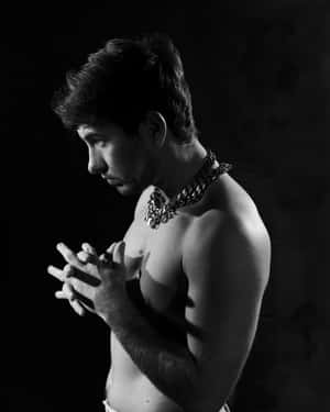 Contemplative Manwith Chain Necklace Wallpaper