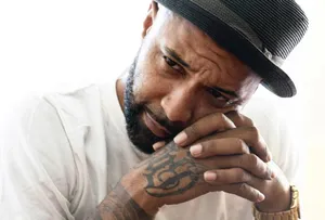 Contemplative Manwith Hatand Tattoos Wallpaper