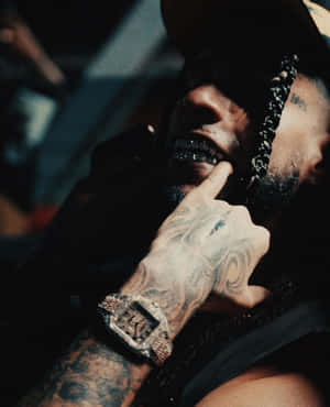 Contemplative Manwith Tattoosand Watch Wallpaper