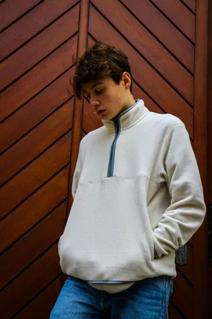 Contemplative Teen White Pullover Wooden Background.jpg Wallpaper