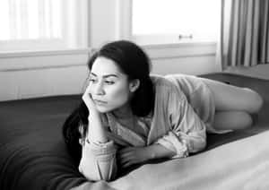 Contemplative Woman Lyingon Bed B W Wallpaper