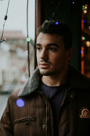 Contemplative Young Man Near Window Wallpaper