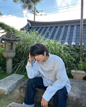 Contemplative Young Man Traditional Korean Setting Wallpaper