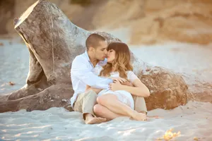 Couple Embracing On The Beach At Sunset Wallpaper