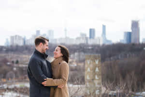 Couple Embracingwith City Skyline Background Wallpaper