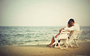 Couple Enjoys A Romantic Sunset On The Beach Wallpaper