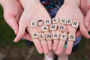 Couple Hands Holding Scrabble Pieces Wallpaper