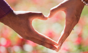 Couple Making Heart Hands Wallpaper