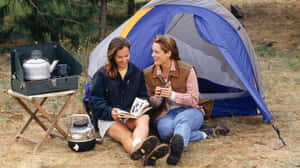 Cozy Fall Camping Under A Canopy Of Vibrant Autumn Foliage Wallpaper