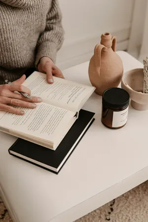 Cozy Reading Momentwith Ceramicsand Candle Wallpaper