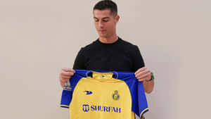 Cristiano Ronaldo Holding Yellow Jersey Wallpaper