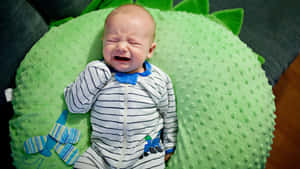 Crying Baby On Green Pillow.jpg Wallpaper