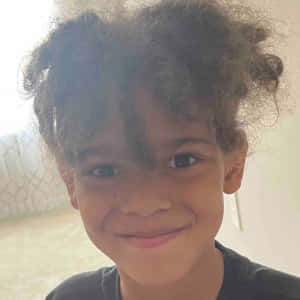 Curly Haired Boy Smiling Wallpaper