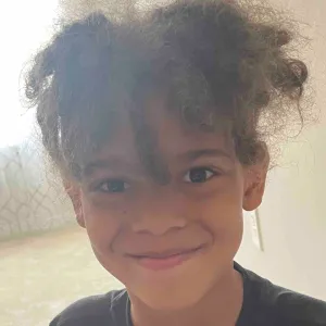 Curly Haired Boy Smiling Wallpaper