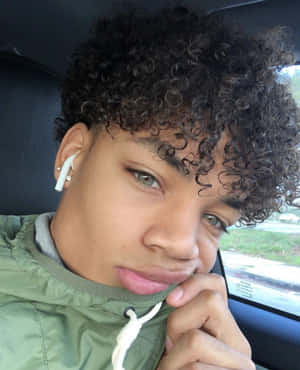 Curly_ Haired_ Boy_with_ Earbud.jpg Wallpaper