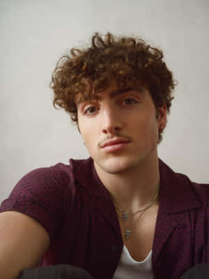 Curly Haired Man In Maroon Shirt Wallpaper