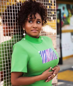 Curly Haired Woman In Green Top Wallpaper