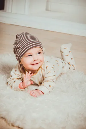 Cute Baby Boy On White Rug Wallpaper