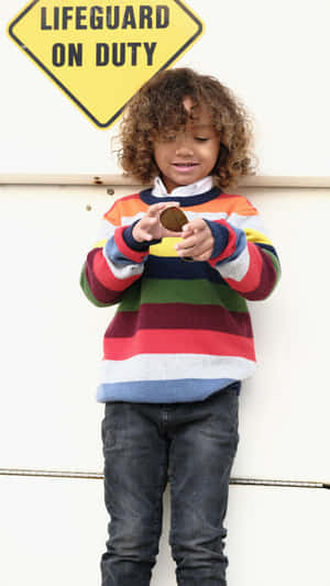 Cute Boy With Curly Hair Under Lifeguard Sign Wallpaper