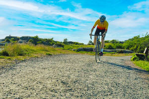 Cycling On Field Dirt Road Wallpaper