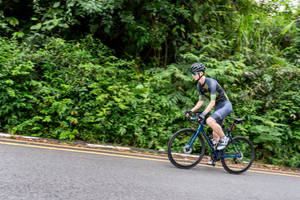 Cycling Uphill On A Country Road Wallpaper