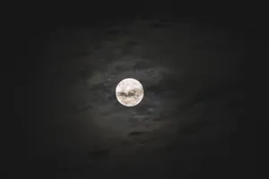 Dark Moon Over An Illuminated Landscape Wallpaper