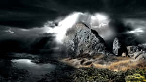 Dark Rock Formation Against A Stormy Sky Wallpaper