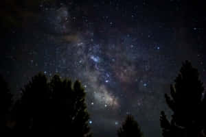 Dark Starry Night Over A Rocky Landscape Wallpaper