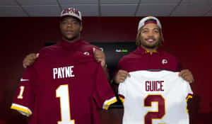 Daron Payneand Teammate Holding Jerseys Wallpaper