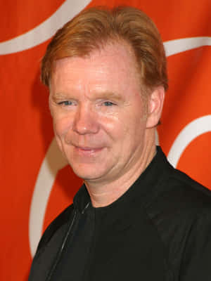 David Caruso Striking A Pose Against A Blurred City Background Wallpaper