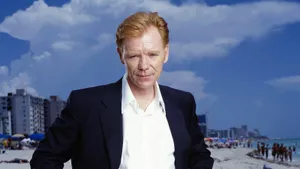 David Caruso Striking A Pose In A Suit Against A City Backdrop Wallpaper