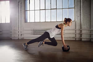Dedicated Athlete Training Abs With Medicine Ball Wallpaper