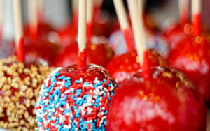 Delectable Candy Apples On Wooden Table Wallpaper