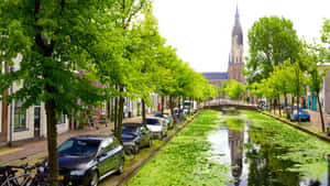 Delft Canal Viewwith Nieuwe Kerk Tower Wallpaper