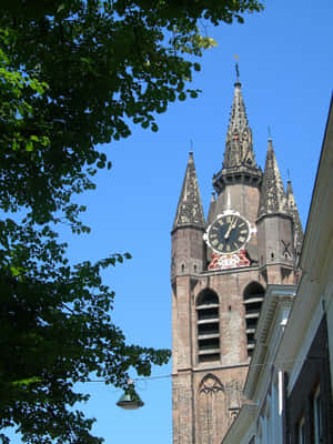 Delft Clock Tower Against Blue Sky Wallpaper