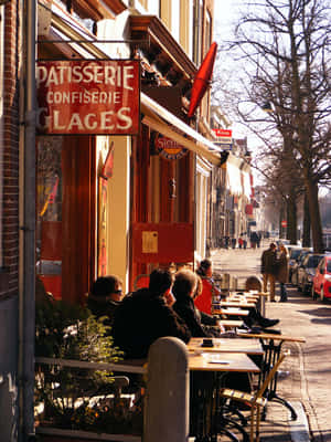 Delft Sidewalk Cafe Patisserie Scene Wallpaper