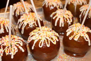 Delicious Caramel Apples On A Rustic Wooden Table Wallpaper