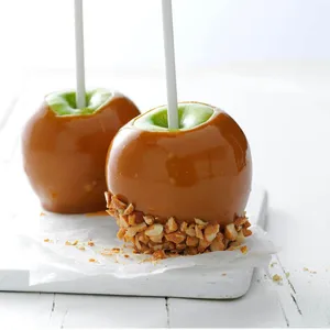 Delicious Caramel Apples On Wooden Table Wallpaper