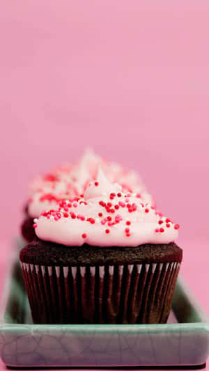 Delicious Cute Cupcake With Colorful Sprinkles And Pink Icing Wallpaper
