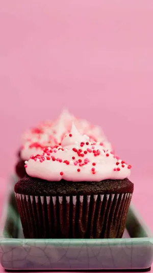 Delicious Cute Cupcake With Colorful Sprinkles And Pink Icing Wallpaper