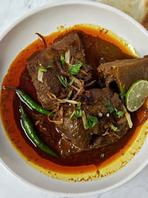 Delicious Nihari Served With Garnishing On A Wooden Table Wallpaper